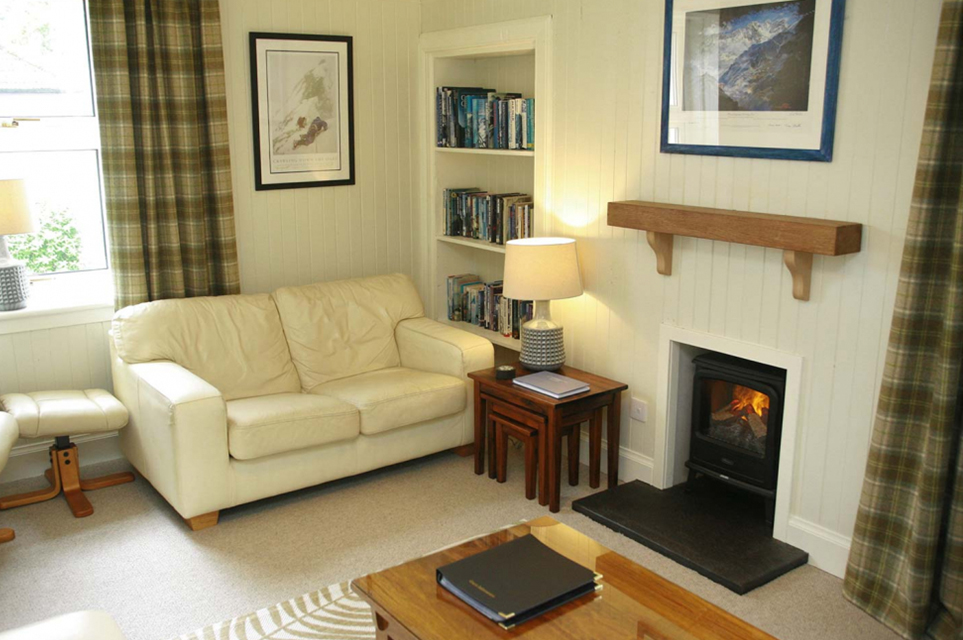 Cozy living room lounge with fireplace, comfortable sofa, and TV at Duart Cottage