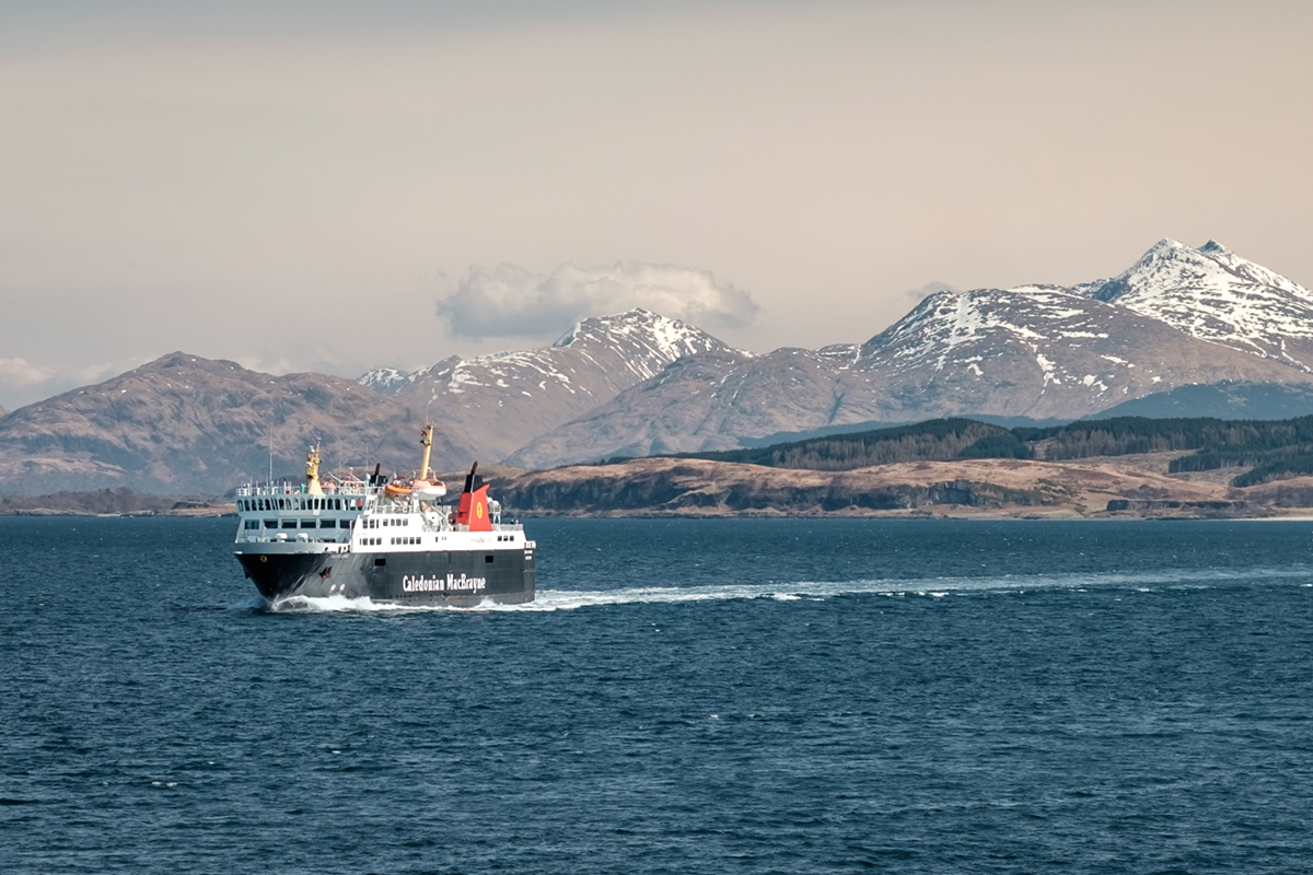 Ferry sailing between Oban and the Isle of Mull with snowcapped highland peaks