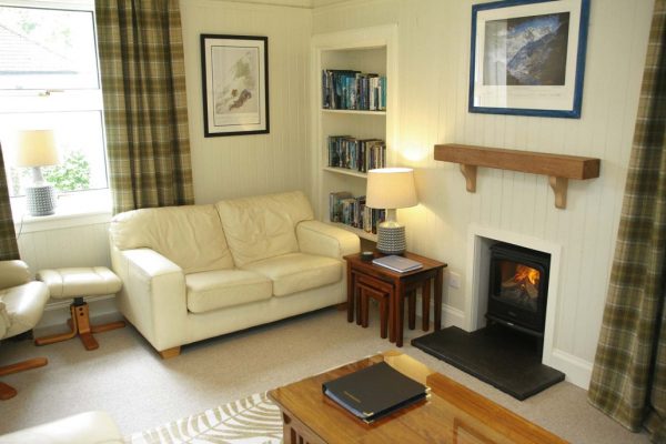 Cozy living room lounge with fireplace, comfortable sofa, and TV at Duart Cottage