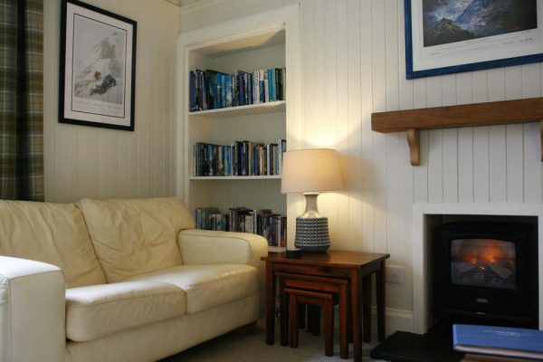 Cozy living room lounge with fireplace, comfortable sofa, and TV at Duart Cottage