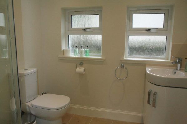 Clean modern bathroom with shower and bath facilities